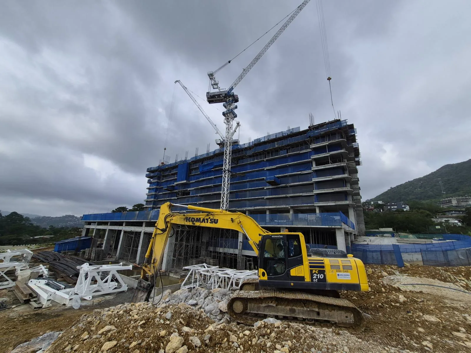 Moncello Crest site photo — tower crane and excavator working the Tuba slope