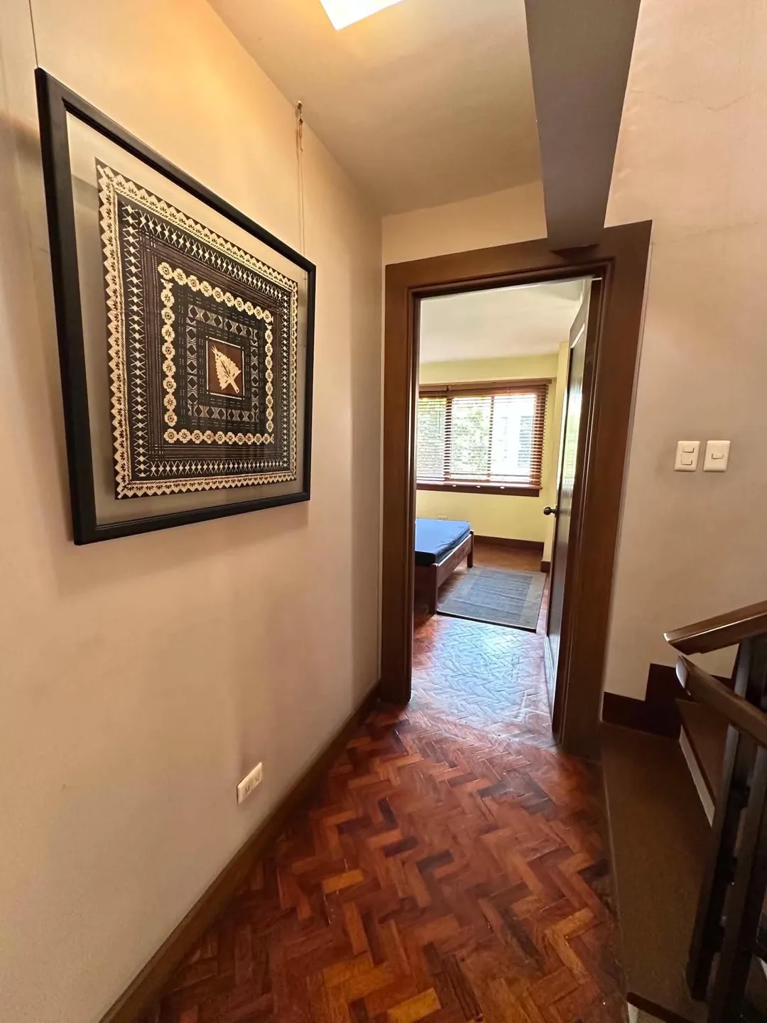 Upstairs hallway with parquet floor leading to a bedroom, Mahogany Place 3